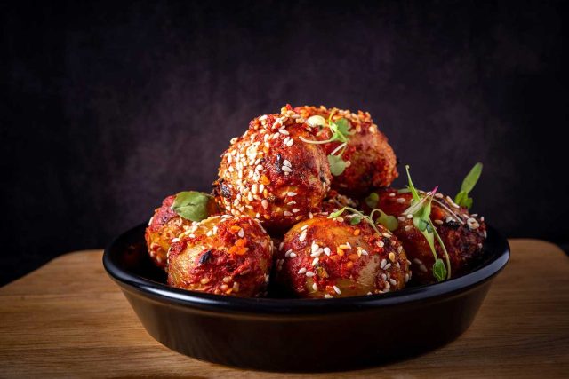 Spicy roasted sesame chilli aloo, showcasing authentic plant-based Indian street food at Chef Atul Kochhar's Wembley Park restaurant.
