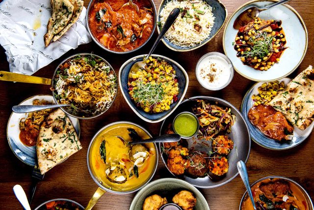 A vibrant spread of authentic Indian street food, featuring aromatic biryani, rich curry, and warm naan bread at Chef Atul Kochhar's Wembley Park restaurant.