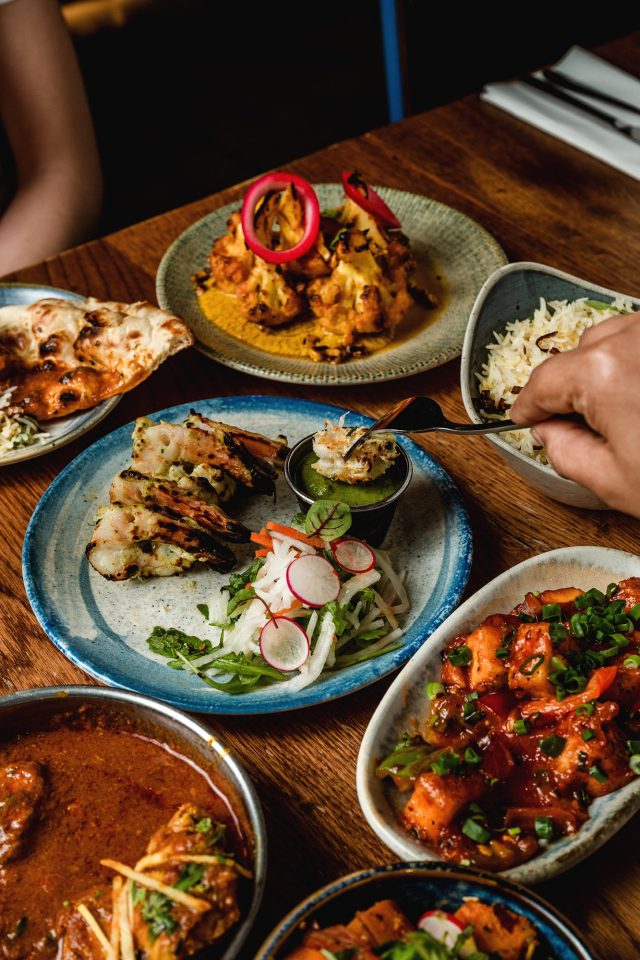 Hand dipping prawn in chutney during an event day Indian meal at Masalchi Wembley.