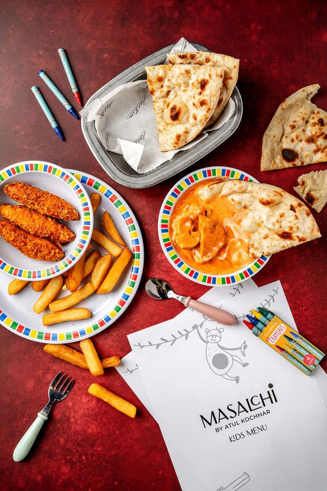 A child's portion of authentic chicken curry served with freshly baked naan, chips, and colouring crayons at Masalchi restaurant in Wembley.